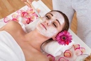 Facial treatment in progress with flower petals on treatment bed
