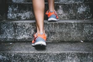 Sneakered feet walking up stone stairs keep legs healthy