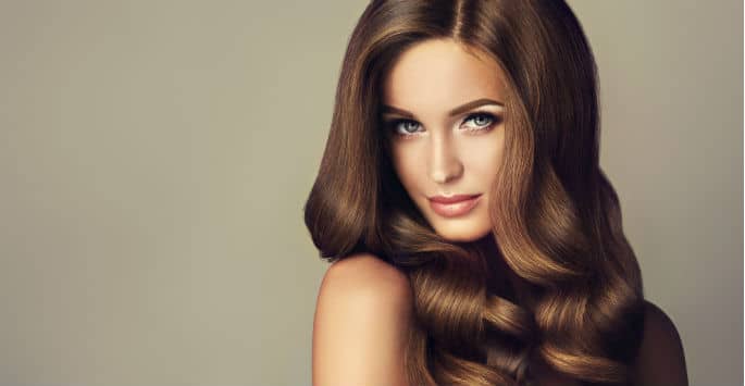 Stunning close up of a model with rich, long-flowing brown wavy hair