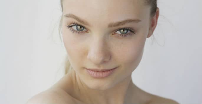 Youthful face of fair-skinned woman with green eyes