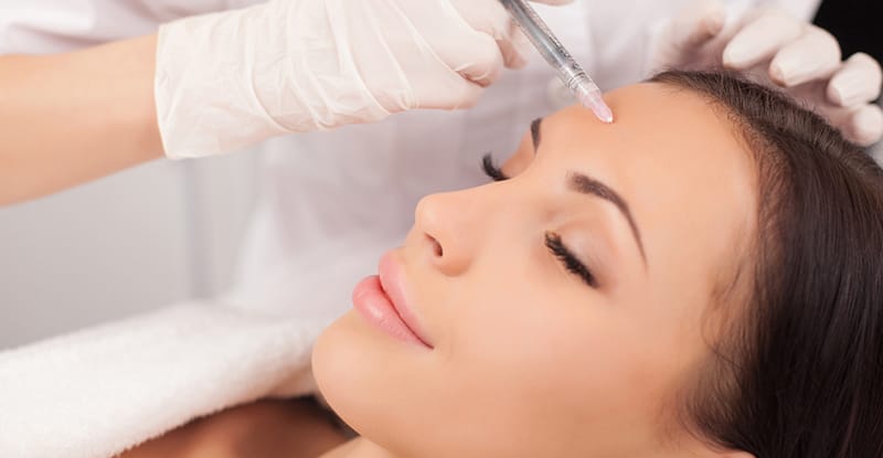 Woman's forehead about to recieve an injection of BOTOX